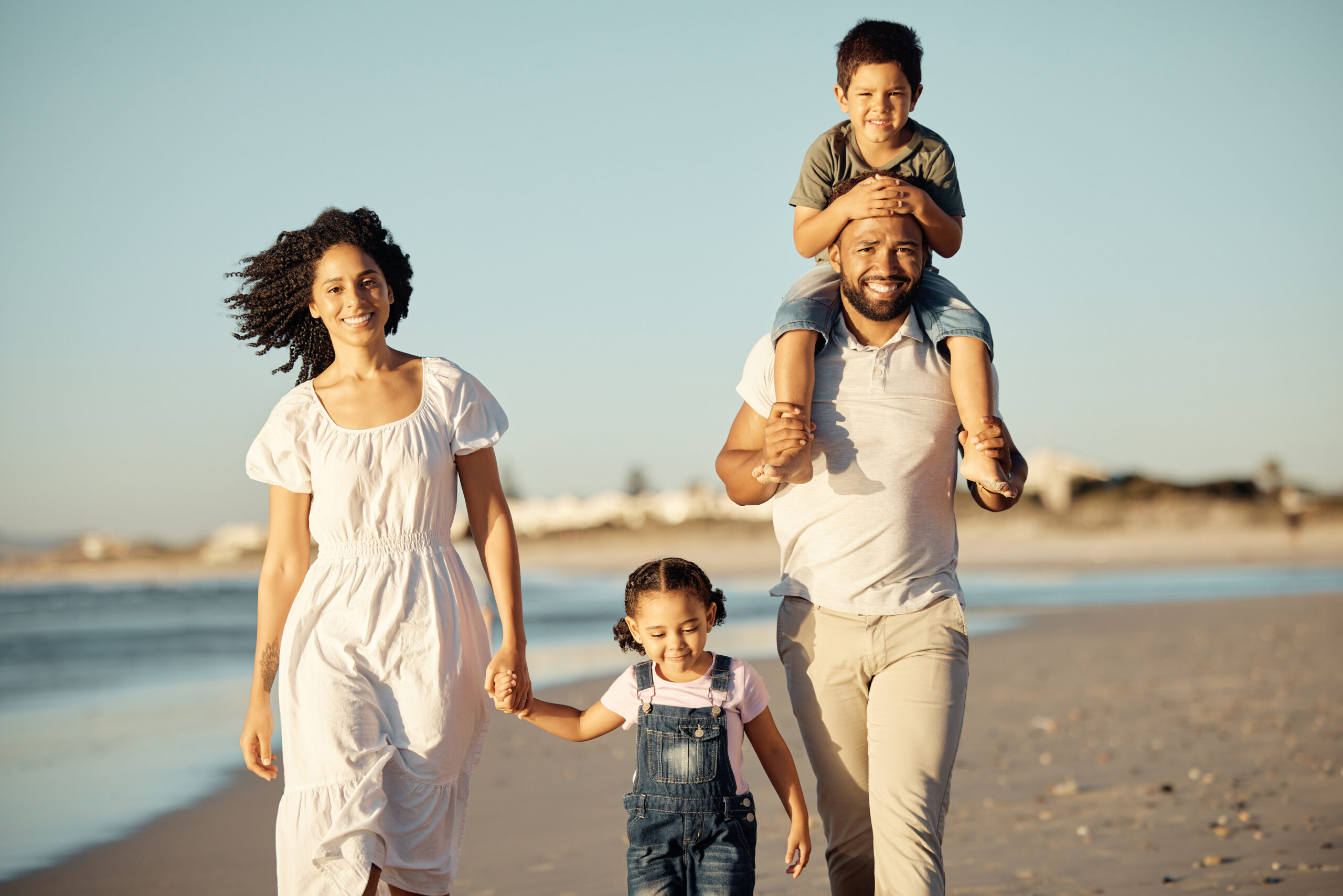 Happy, beach and walking with family at sunset on holiday for love, summer and travel together. Smile, nature and sunshine with portrait of parents and children on Miami Florida vacation by the sea.